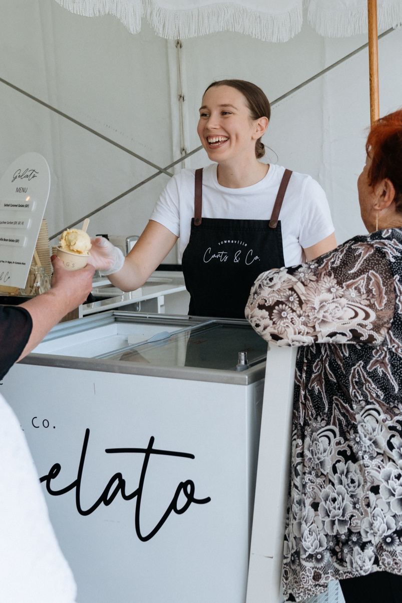 A Carts & Co attendant handing a cup of gelato to a guest